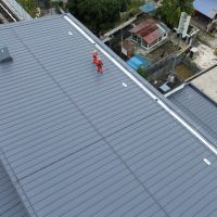 Worker wearing fall arrest PPE on rooftop